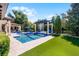 Beautiful backyard featuring pool with waterfall, manicured lawn, and lush landscaping at 1517 Edenhall Pt, Lake Mary, FL 32746