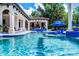 Tranquil pool area with comfortable lounge chairs, covered dining area, and vibrant blue accents at 1517 Edenhall Pt, Lake Mary, FL 32746