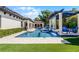 Lush backyard featuring pool with water feature, manicured lawn, and covered patio at 1517 Edenhall Pt, Lake Mary, FL 32746