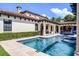 Luxury pool with waterfall feature, travertine tile deck, and manicured backyard at 1517 Edenhall Pt, Lake Mary, FL 32746