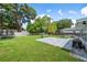 Spacious backyard featuring a grassy lawn, patio area, mature tree, and recreational equipment at 2102 Ivanhoe Rd, Orlando, FL 32804