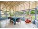 Enclosed sun room with lots of windows, stylish hanging chair, and dining area at 2102 Ivanhoe Rd, Orlando, FL 32804