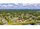 Aerial view of the home in a lovely neighborhood, surrounded by lush greenery and tree canopy with a clear blue sky at 2356 Date Palm Dr, Edgewater, FL 32141