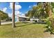 Charming single-story home featuring a lush green lawn and mature trees in the front yard at 2356 Date Palm Dr, Edgewater, FL 32141