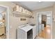 Organized laundry room with front load washer and dryer, overhead storage, and access to other rooms at 2356 Date Palm Dr, Edgewater, FL 32141