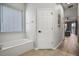 Bright bathroom featuring tub with jets, window, and tile floor at 2451 Ridgemoor Dr, Orlando, FL 32828