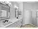 Bathroom featuring double sinks, quartz countertop, and glass enclosed shower at 2451 Ridgemoor Dr, Orlando, FL 32828
