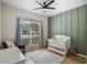 Charming Bedroom featuring a white crib, accent wall, and soft natural light from a large window at 2451 Ridgemoor Dr, Orlando, FL 32828