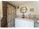 Bathroom with shower, white vanity, decorative mirror, and tiled walls at 316 Amanda Ln, Leesburg, FL 34748
