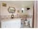 Bathroom features a white vanity, decorative mirror, and tiled walls at 316 Amanda Ln, Leesburg, FL 34748