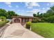 Inviting single-Gathering home with a paved driveway, lush lawn, mature landscaping, and decorative fountain at 316 Amanda Ln, Leesburg, FL 34748