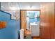 Functional laundry room featuring a washer, dryer, shelving, and blue accent wall at 316 Amanda Ln, Leesburg, FL 34748