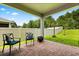 Covered brick patio area with cozy seating, perfect for enjoying outdoor living at 31924 Geoff, Sorrento, FL 32776