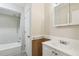Clean bathroom with white fixtures, shower-tub combo, and wooden accent paneling at 3226 Midnight Star Ct, Kissimmee, FL 34744