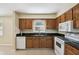 Kitchen with wooden cabinets, black countertops, white appliances, and tile flooring at 3226 Midnight Star Ct, Kissimmee, FL 34744