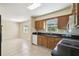 Functional kitchen featuring wooden cabinets, black countertops, and tile flooring at 3226 Midnight Star Ct, Kissimmee, FL 34744