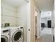 Bright laundry area with white washer and dryer, tile floors, and a view into a bathroom at 3226 Midnight Star Ct, Kissimmee, FL 34744