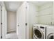 Well-lit laundry room with a full-size washer and dryer and some shelves at 3226 Midnight Star Ct, Kissimmee, FL 34744