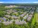 Wide aerial view of homes with lush landscaping and a pond in the community at 3599 Caruso Pl, Oviedo, FL 32765