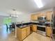 Kitchen with stainless appliances and plenty of countertop space that leads to the living and dining room at 3599 Caruso Pl, Oviedo, FL 32765