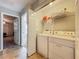 Laundry room with washer, dryer, shelving, and tile flooring, conveniently located at 3599 Caruso Pl, Oviedo, FL 32765