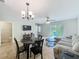 Open-concept living and dining area featuring tile floors, a sliding glass door to the outdoors, and comfortable seating at 3599 Caruso Pl, Oviedo, FL 32765