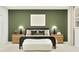 Serene bedroom with green accent wall, stylish lamps, and a comfortable bed with pillows at 373 Sol Vista Dr, Dundee, FL 33838