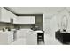 Modern kitchen boasts white cabinetry, stainless steel appliances, and sleek island seating at 373 Sol Vista Dr, Dundee, FL 33838