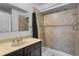 The vanity in this bathroom has granite counters and updated faucets, with a tile shower at 3997 Versailles Dr # 3997F, Orlando, FL 32808