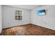 Bedroom with wood flooring, a window, and a flatscreen TV mounted on the wall at 3997 Versailles Dr # 3997F, Orlando, FL 32808