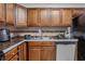 Close-up kitchen view showcasing wood cabinets, tile backsplash, stainless steel appliances, and ample counter space at 3997 Versailles Dr # 3997F, Orlando, FL 32808