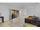 Bright living room with ceramic tile flooring, modern sofa, entertainment center and sliding glass doors at 3997 Versailles Dr # 3997F, Orlando, FL 32808