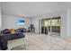 Bright living room with ceramic tile flooring, modern sofa, entertainment center and sliding glass doors at 3997 Versailles Dr # 3997F, Orlando, FL 32808
