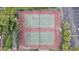 Aerial view of two tennis courts surrounded by trees and parking, offering a recreational amenity for residents at 3997 Versailles Dr # 3997F, Orlando, FL 32808