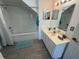 Bright bathroom featuring a soaking tub, single sink vanity, and wood look tile flooring at 4002 San Gallo Dr # 105, Kissimmee, FL 34741