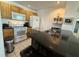 Functional kitchen boasting wooden cabinets, white appliances, and a convenient breakfast bar with granite countertop at 4002 San Gallo Dr # 105, Kissimmee, FL 34741
