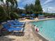 Community pool featuring blue lounge chairs, water features, and lush landscaping at 4002 San Gallo Dr # 105, Kissimmee, FL 34741