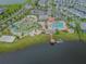 Aerial view of a Primary-planned community with a lazy river, basketball court, and volleyball court by a lake at 4367 Rhyme St, Kissimmee, FL 34746