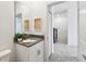 Charming bathroom with vanity, wall mirror, and view into hallway and stairwell at 4367 Rhyme St, Kissimmee, FL 34746