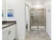 Bathroom featuring a walk-in shower, quartz countertops, white cabinets, and tile flooring at 4367 Rhyme St, Kissimmee, FL 34746
