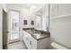 Bathroom featuring double vanity, granite countertop, and door to screened outdoor pool at 4367 Rhyme St, Kissimmee, FL 34746