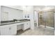 Bathroom featuring double sinks, quartz countertops, white cabinets, a walk-in shower, and a separate toilet at 4367 Rhyme St, Kissimmee, FL 34746