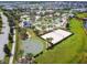 Aerial view of community amenities including a lazy river, volleyball court, and basketball court near a lake at 4367 Rhyme St, Kissimmee, FL 34746