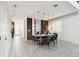 Dining room with an oval table, six green velvet chairs, pendant lighting, and elegant decor on tiled floor at 4367 Rhyme St, Kissimmee, FL 34746