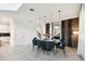 Dining room with a table, six velvet chairs, decorative lighting, and tiled flooring, connecting to a kitchen at 4367 Rhyme St, Kissimmee, FL 34746