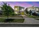 Striking two-story home with modern design, lush landscaping, and a yellow accent garage door at 4367 Rhyme St, Kissimmee, FL 34746