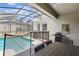 Screened outdoor patio featuring outdoor dining, a grill, and backyard pool views at 4367 Rhyme St, Kissimmee, FL 34746