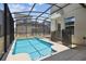 Relaxing backyard featuring a pool and hot tub within a screened enclosure at 4367 Rhyme St, Kissimmee, FL 34746