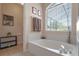Bright bathroom featuring a soaking tub with a large window and stylish decor at 5226 Smokey Water Ln, Oviedo, FL 32765