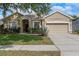 Charming single-story home with a well-manicured lawn, lush landscaping, and a two-car garage at 5226 Smokey Water Ln, Oviedo, FL 32765
